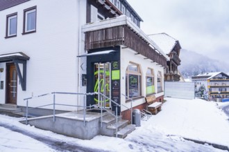 Snow-covered building with wooden details in a mountainous village in cold weather, Tante M,