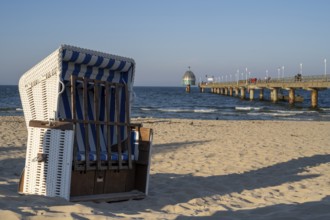 Beach chair on the sandy beach, tourists on the Vineta Bridge, pier with diving gondola, Zinnowitz,