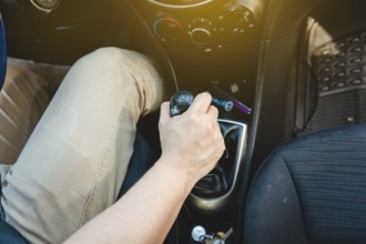 Driver hand grabbing car gear stick, closeup of hands accelerating on gear stick. Close-up of