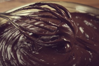 A bowl of chocolate dough, a whisk for whipping, baking, structure and consistency, homemade, top
