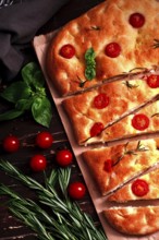 Focaccia, Italian flatbread, with cherry and rosemary, close-up, garlic bread, top view, vertical,