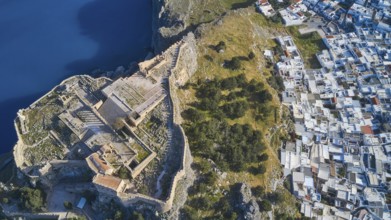 Drone shot, Acropolis of Lindos, late afternoon light, aerial view of an ancient fortress on the