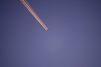 Aeroplane with contrails, evening sun, Germany, Europe