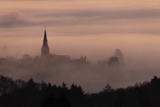 Wisps of mist drift into the town of Kronberg im Taunus in the morning shortly in front of sunrise.