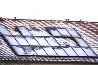 Snow-covered solar modules on a residential building, winter, Germany, Europe