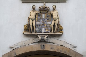 Coat of arms with crown and two men, Stormgade 10, Copenhagen, Denmark, Europe