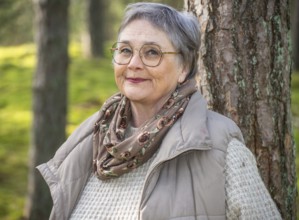 Portrait of elderly woman, 65 years old, enjoying nature in the forest in Ystad, Skåne, Sweden,