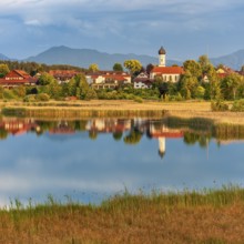 View over the Sengsee lake to Iffeldorf with St. Vitus church in autumn, Osterseen, Fünfseenland,