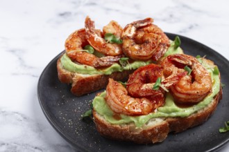 Sandwiches with avocado and caramelized shrimp, micro-greens, breakfast, on a plate, top view,