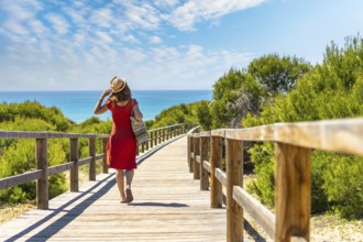 A young girl on the wooden path to Playa Moncayo in Guardamar del Segura next to Torrevieja,
