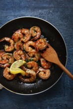 Fried tiger prawns, jumbo, in garlic sauce, in butter, with herbs, in a frying pan, homemade, no