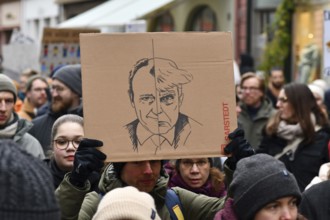 Heidelberg, Germany - February 12th 2025: Person holding up sign comparing CDU politian Friedrich