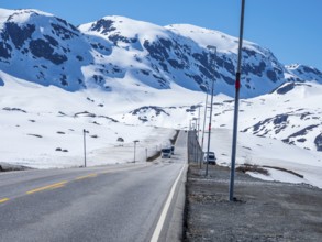 Camper vans driving through snowy high mountain landscape, Haukelivegen road, E134, Norway, Europe