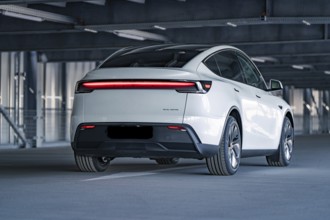 Rear of a modern electric car with eye-catching LED strip in a multi-storey car park, Tesla New