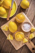 Preserved, salted canned lemons, lemon pickle on wooden background. Moroccan cuisine
