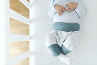 directly above view of four day old newborn baby boy in baby crib
