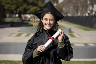 Woman recent graduated, dressed in cap and gown, showing off his degree celebrating