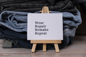 WEAR REPAIR REMAKE REPEAT text on paper note on Jeans clothes assortment Second hand sustainable