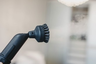 Steam cleaner's brush head with a blurry white background
