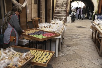 Bari, Italy, 27 November, 2023: woman pasta maker laying out her wares in the iconic Strada del