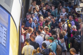 Many people crowded on a platform in front of a local train, chaos in local transport, Hamburg