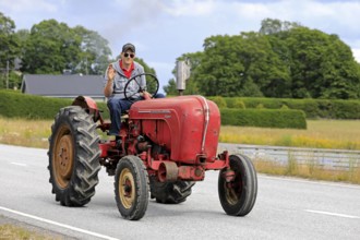 Kimito, Finland. July 6, 2019. Young man greets as he drives classic Porsche-Diesel Super Tractor