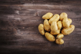 Fresh organic potatoes on a wooden table with copy space