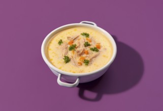 Delicious greek chicken soup with lemon juice and vegetables, in a white enamel bowl, isolated on a