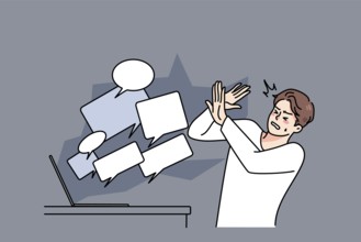 Stressed man overwhelmed with online negative comments and messages on computer. Unhappy guy