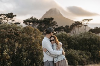 Couple standing in front of Signal Hill at sunset, Cape Town, South Africa, Africa