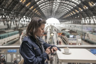 Woman in a Restaurant Drinking Coffee and Looking at Her Watch in Railroad Station in Milan,