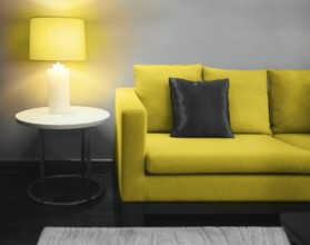 Cozy beautiful living room with illuminating yellow sofa and lamp with copy space. Toned image