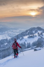 Pretty active senior woman snowshoeing in the Allgäu Alps near Oberstaufen with a view of the
