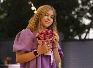 Cute teen girl with rose flowers. Child playing in summer garden. Kids gardening. Children play