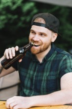 Man opening beer bottle cap with his teeth