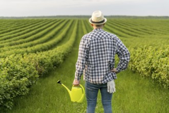 Man farmland with watering can