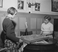 In the 1950s. Two girls are playing the Ice Hockey game Puck. Manufactured by Swedish company