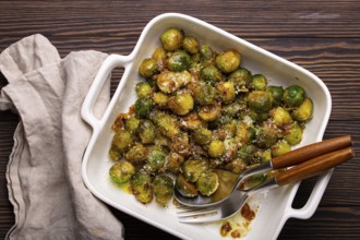 Healthy vegetarian dish roasted brussels sprouts with butter and parmesan cheese in white ceramic