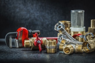 Plumbing brass pipe connectors on dark background