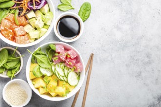 Two assorted poke bowls with raw fish and vegetables, space for text. Top view, close up. Hawaiian