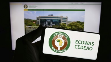 Stuttgart, Germany, 02-15-2024: Person holding smartphone with logo of Economic Community of West
