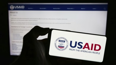 Stuttgart, Germany, 11-27-2023: Person holding cellphone with logo of United States Agency for