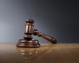 Mahogany wooden gavel on glossy wooden table