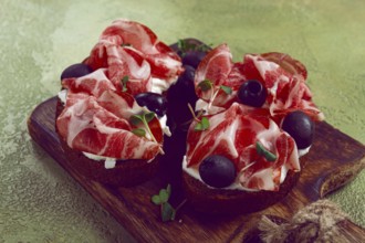 Sliced cured ham, sandwiches with prosciutto and black olives, Italian dish, delicacy, Parma ham,