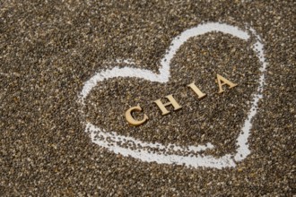 Heart made of chia seeds with word CHIA inside background. Healthy superfood rich in Omega 3 fatty