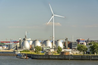 Gas storage reservoir and large wind turbine in the harbour area in Hamburg, Germany, Europe