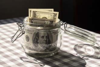 Dollar banknote saving money in glass jar. Consumption and economy Collecting money. Tips.