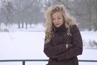 freezing woman in heavy snowfall suffering from winter depression
