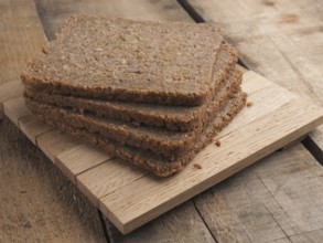 Wholemeal rye bread on a rustic wooden table, healthy food concept