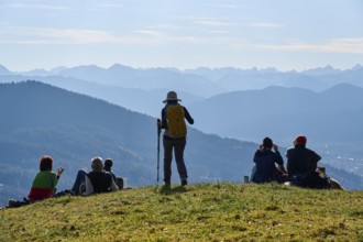 Hikers rest on the summit of Sonntratn, also known as Schürfenkopf, and look into the Karwendel,